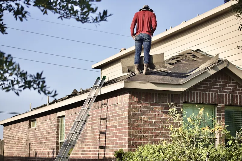 Professional roofer working on a residential roof in Byfield